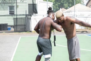 a couple of men standing on top of a tennis court