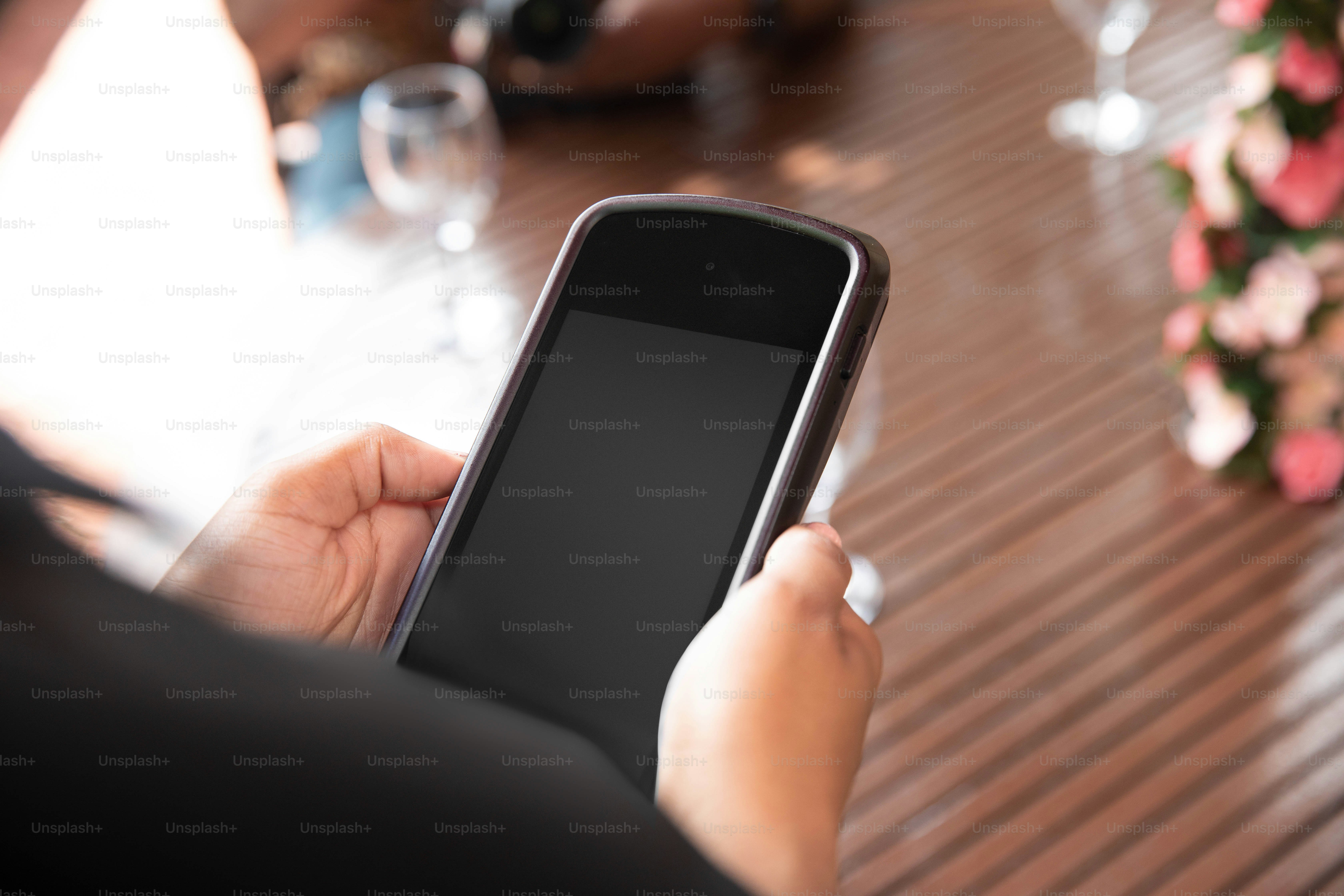 seseorang memegang ponsel pintar di tangan mereka