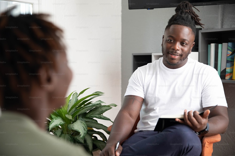 a man sitting in a chair with a plant in front of him