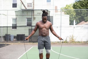 a man with no shirt on holding a tennis racket