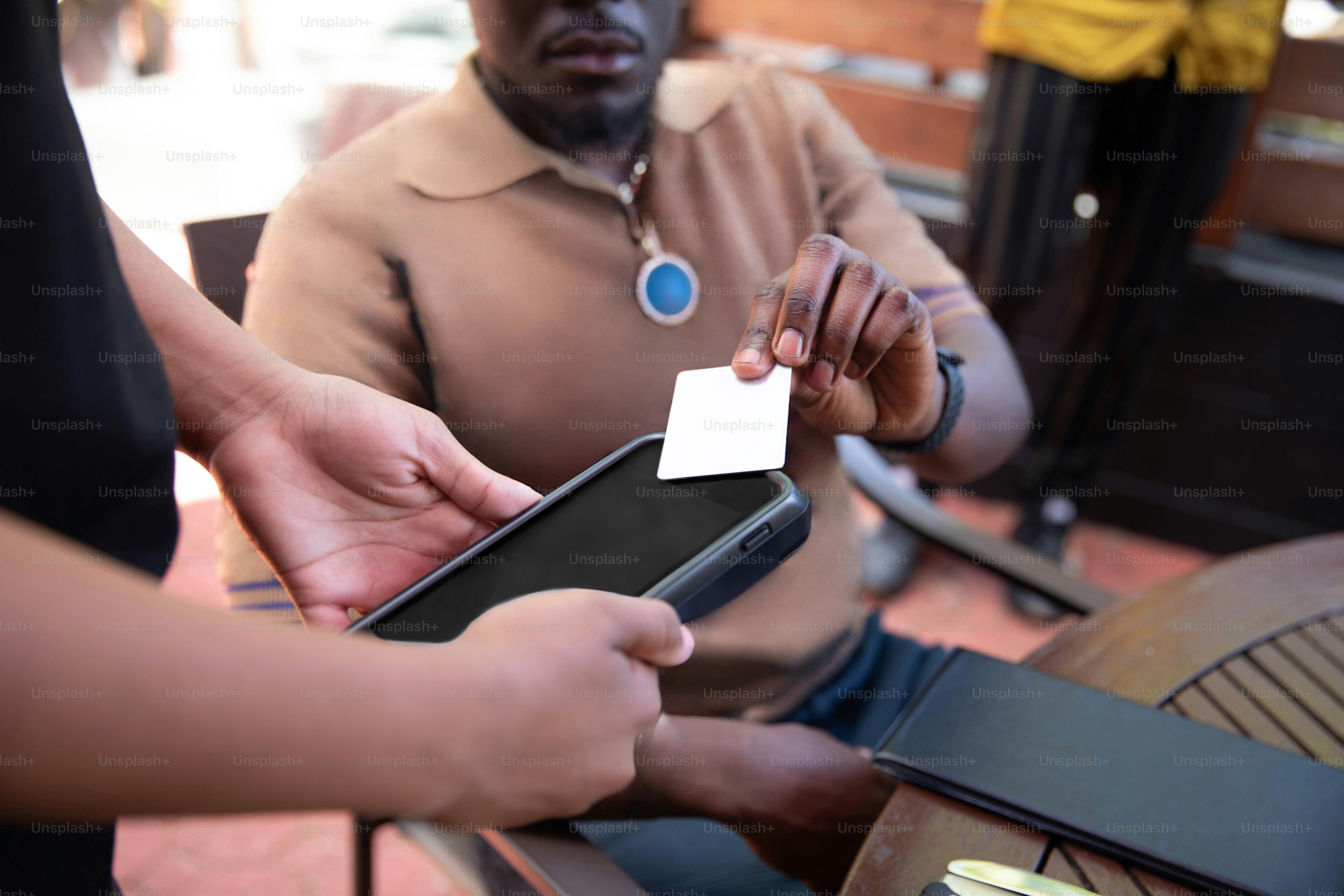 a man holding a smart phone and a white business card