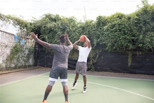 a couple of men standing on top of a tennis court