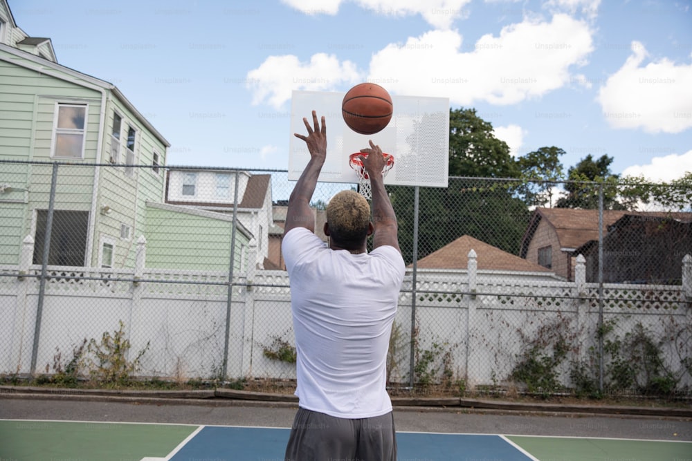 a man in a white shirt is playing basketball
