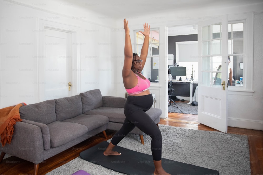 Una mujer está haciendo yoga en una sala de estar