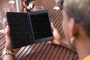 a person holding a tablet on a wooden table