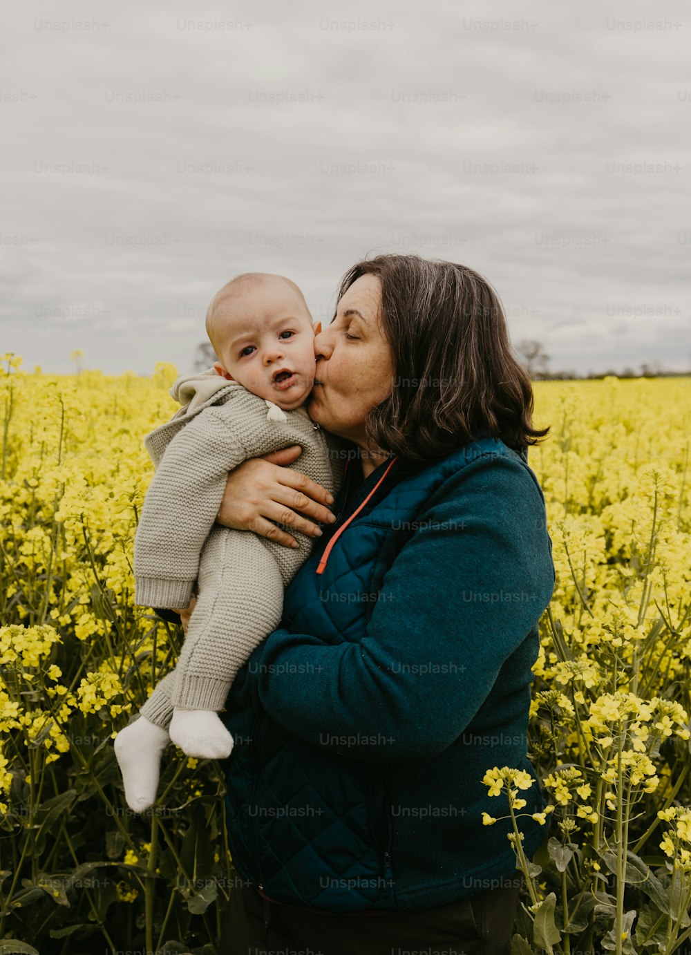 黄色い花畑で赤ん坊を抱く女性