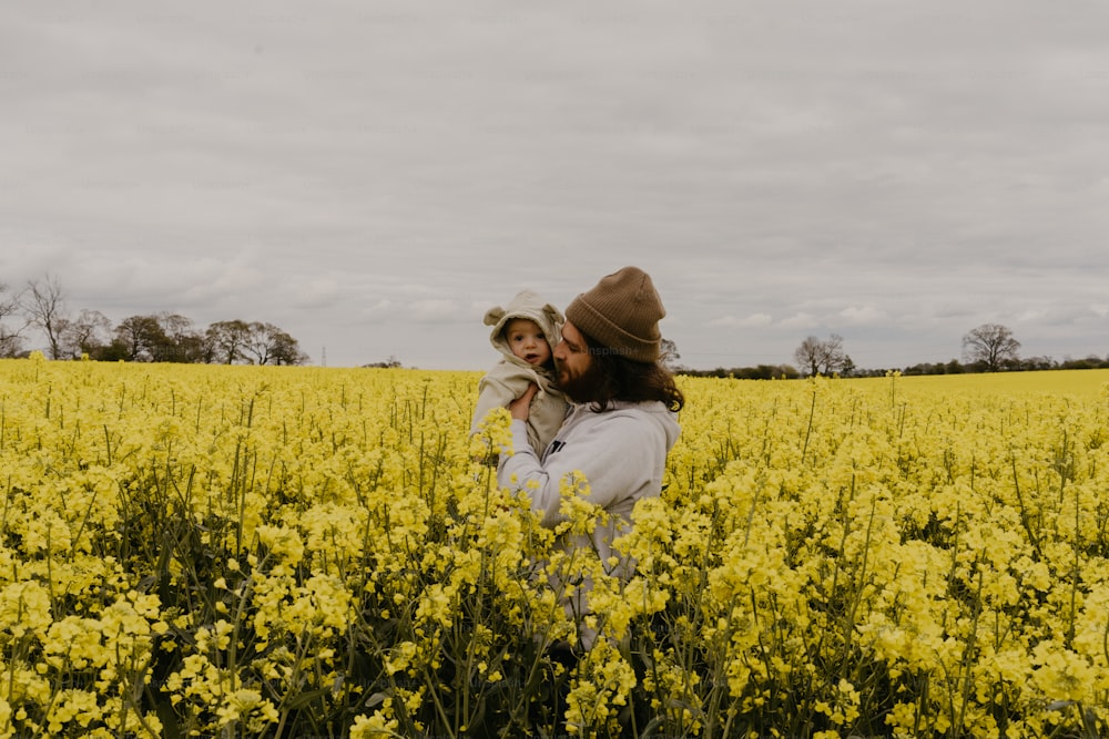 a man and a woman standing in a field of yellow flowers