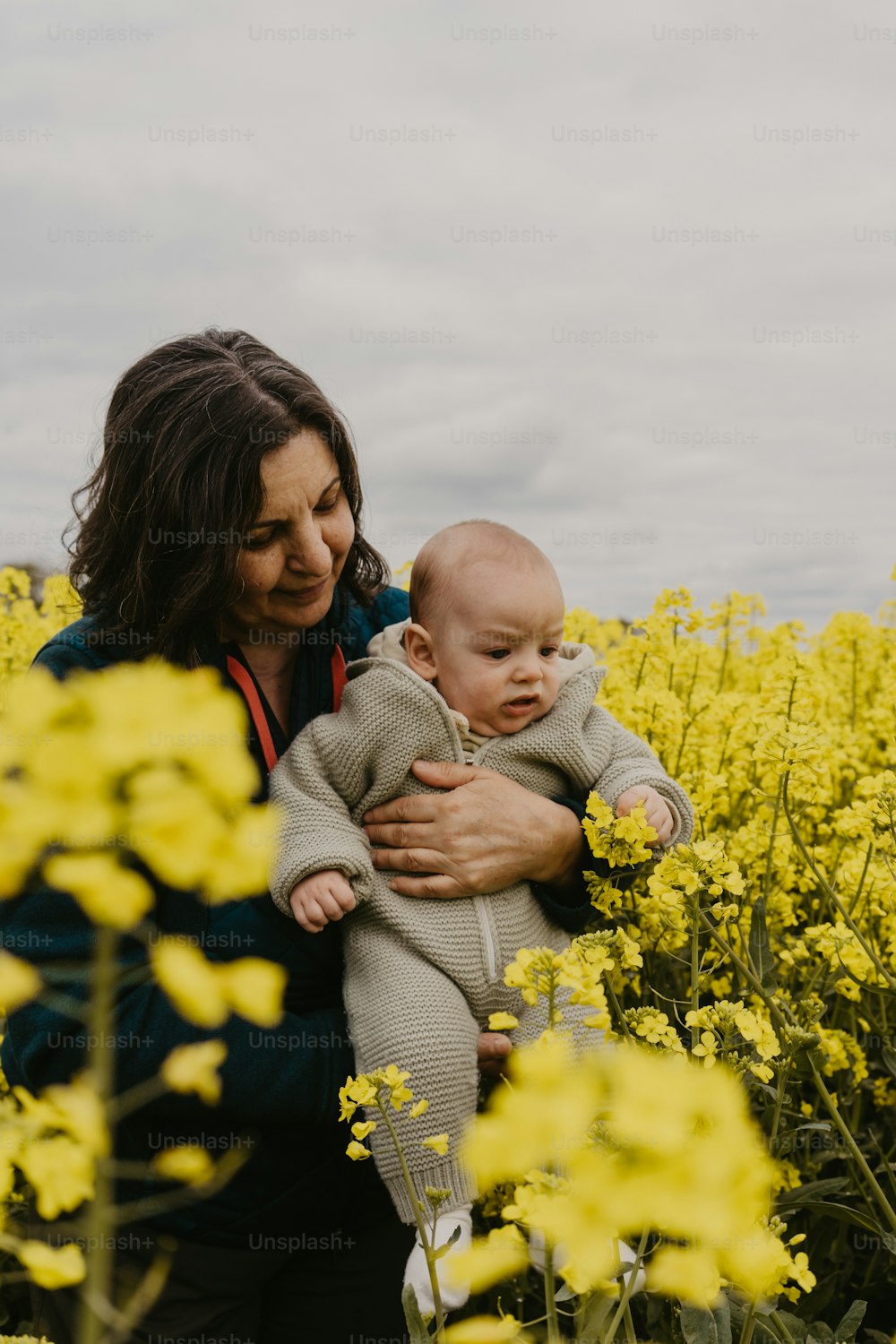 노란 꽃밭에서 아기를 안고 있는 여자