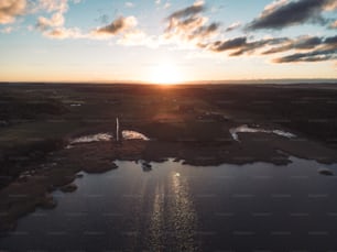 the sun is setting over a small lake