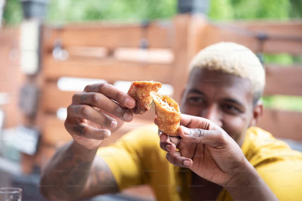 Un hombre sosteniendo una rosquilla a medio comer en la mano