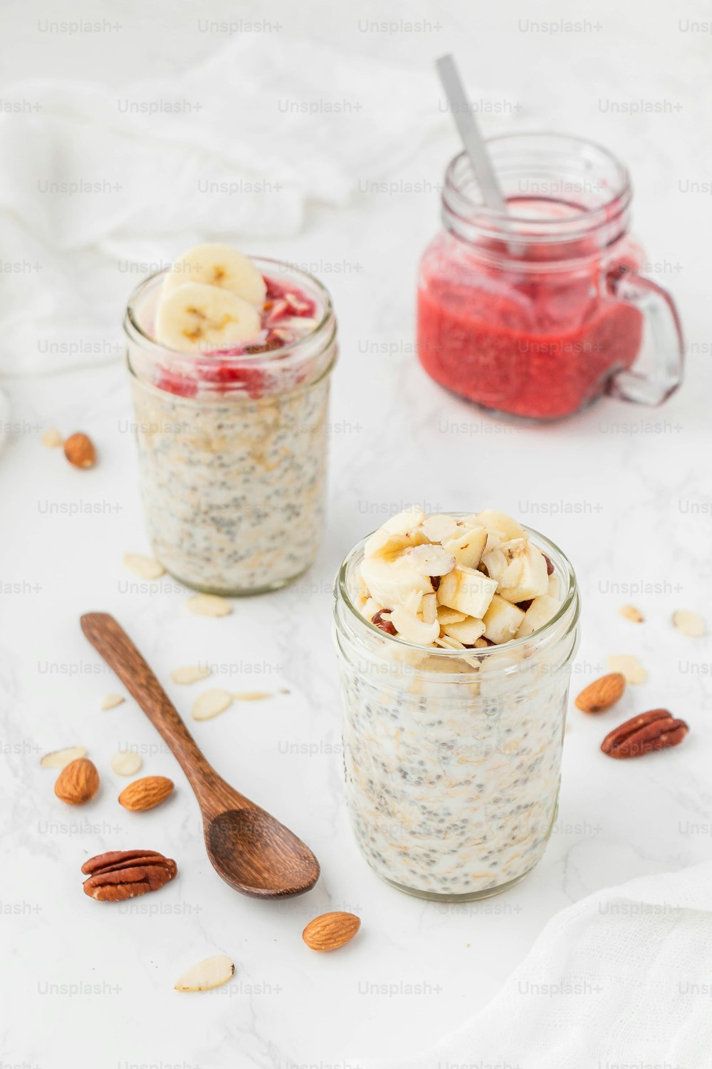 two jars filled with oatmeal, nuts, and fruit