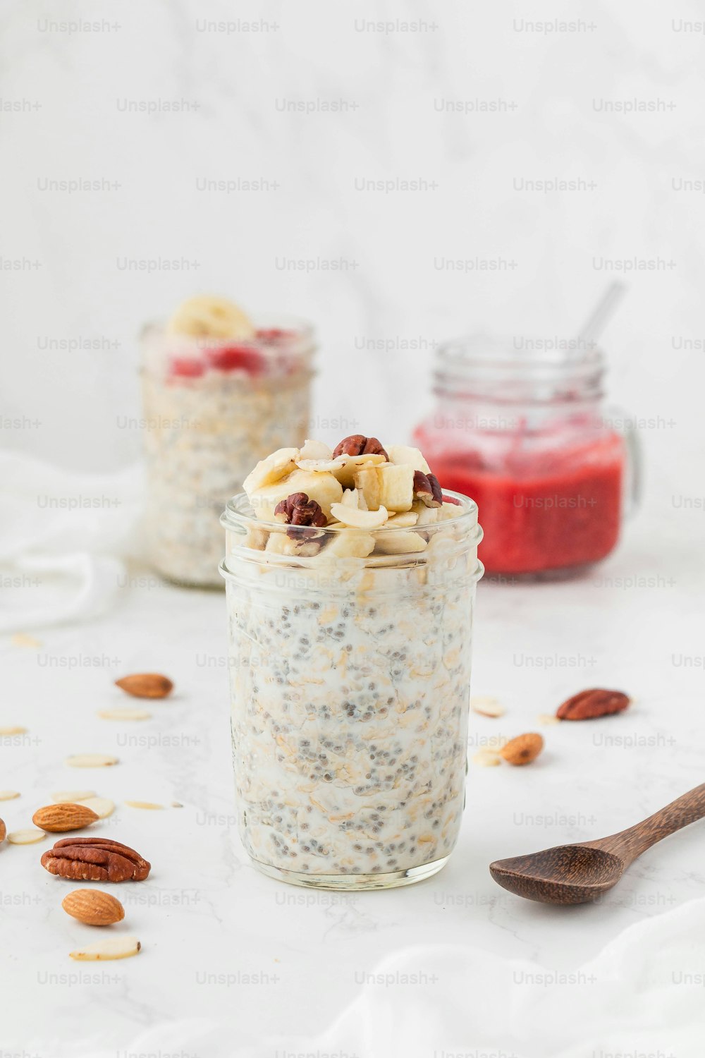 a jar filled with oatmeal and nuts next to a spoon