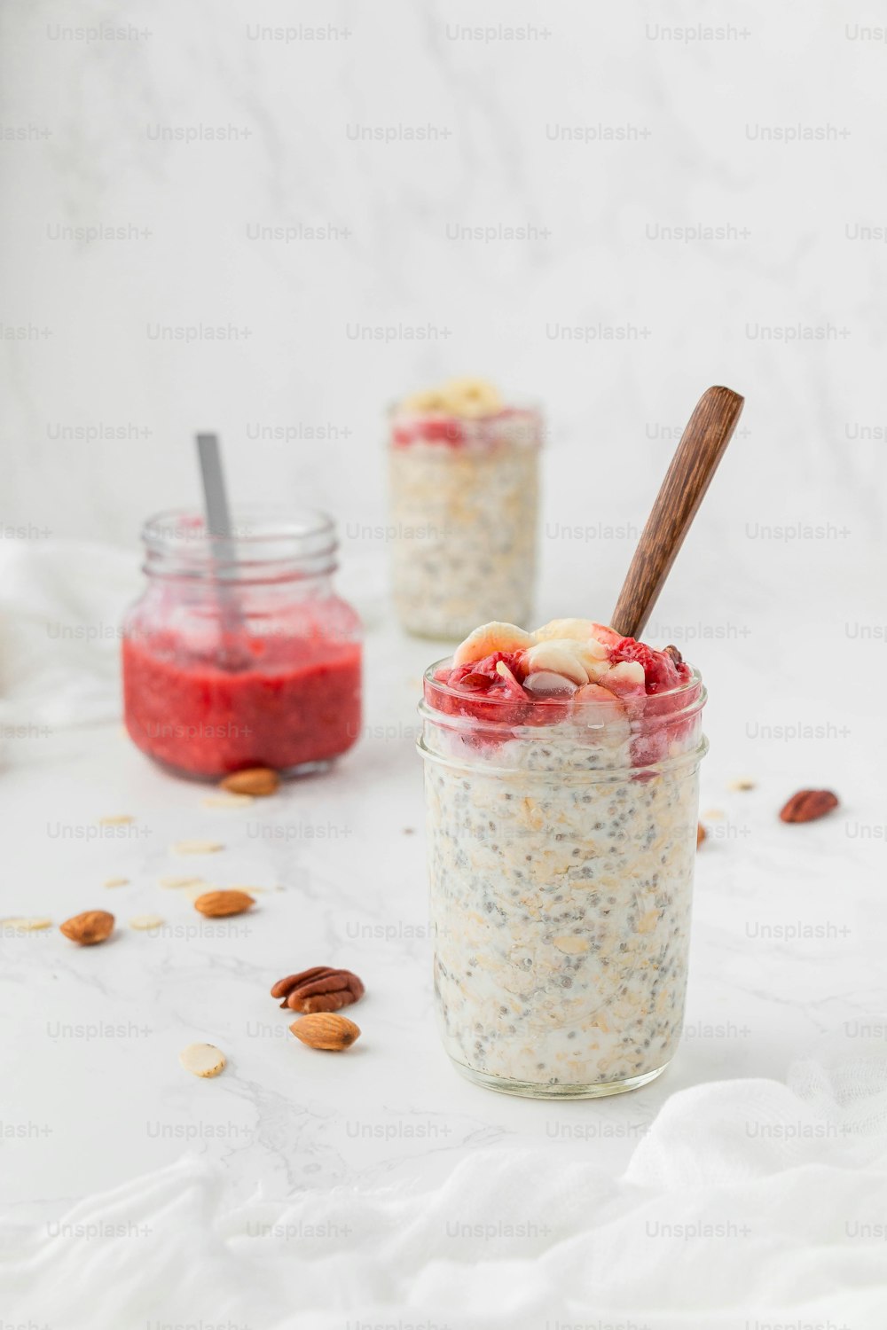 two jars of overnight oatmeal with a wooden spoon