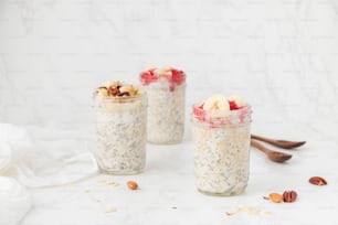 trois pots de flocons d’avoine avec des fruits et des noix