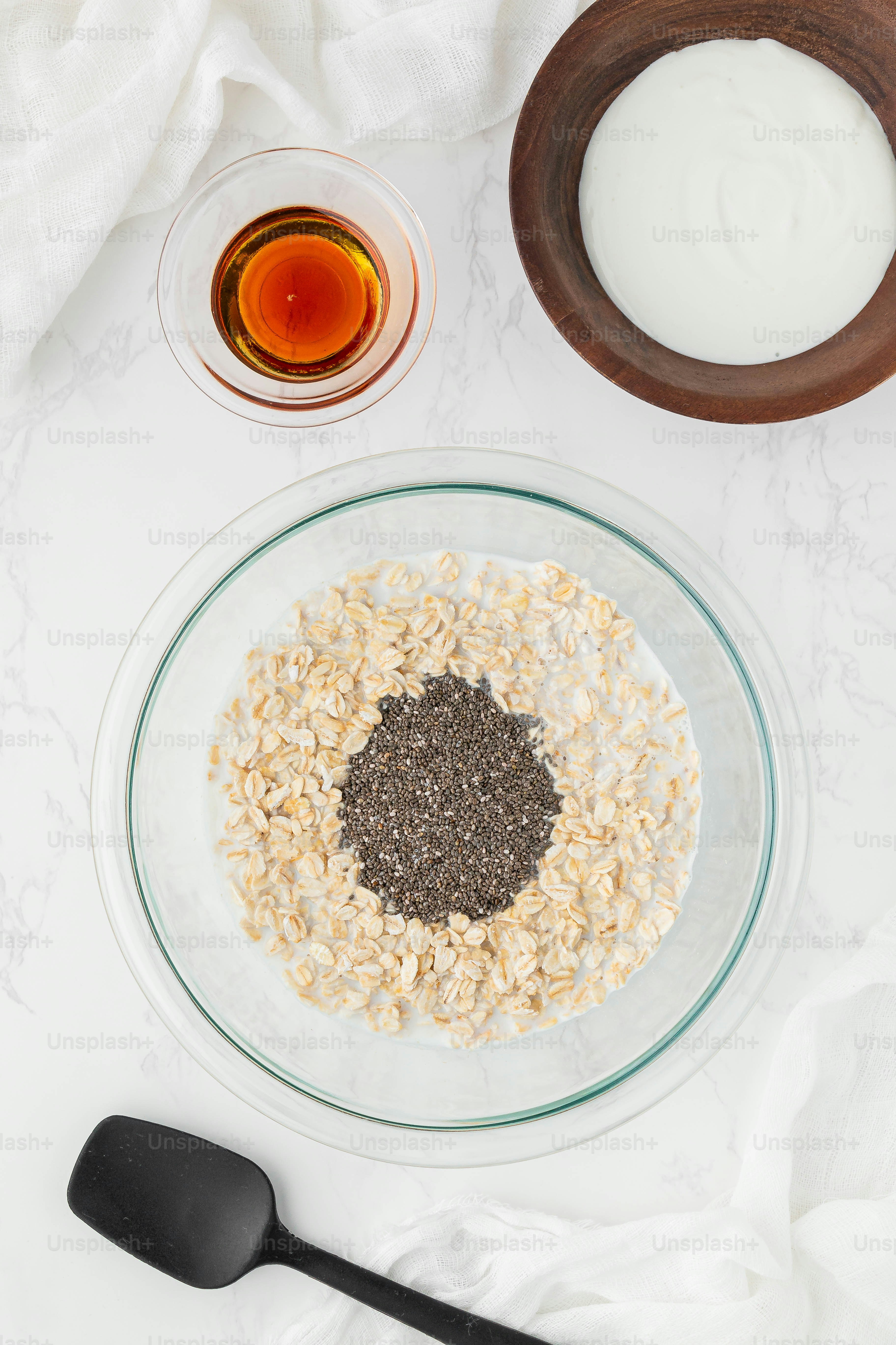 a bowl of oatmeal next to a bowl of milk and a spoon