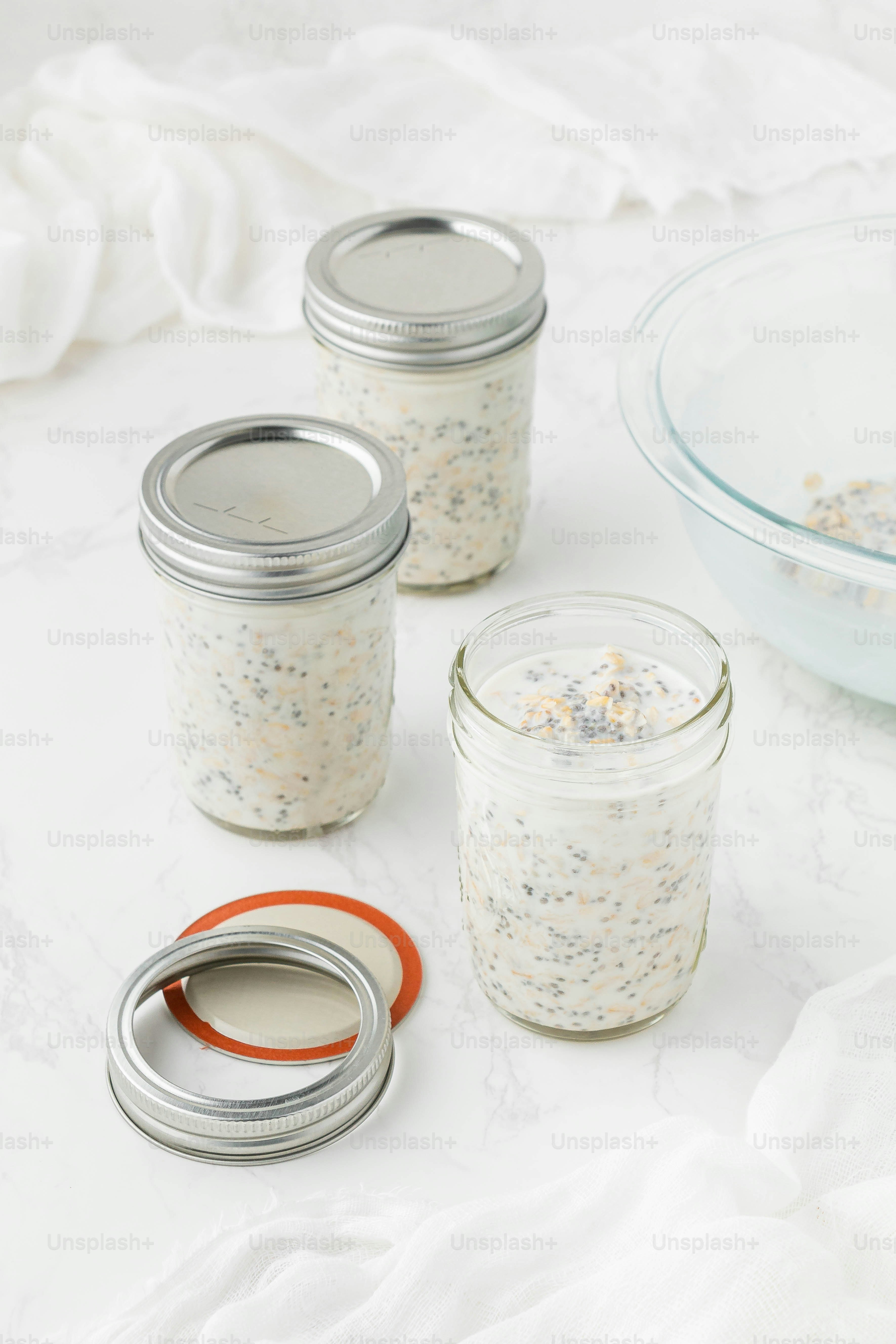 a table topped with three jars filled with food