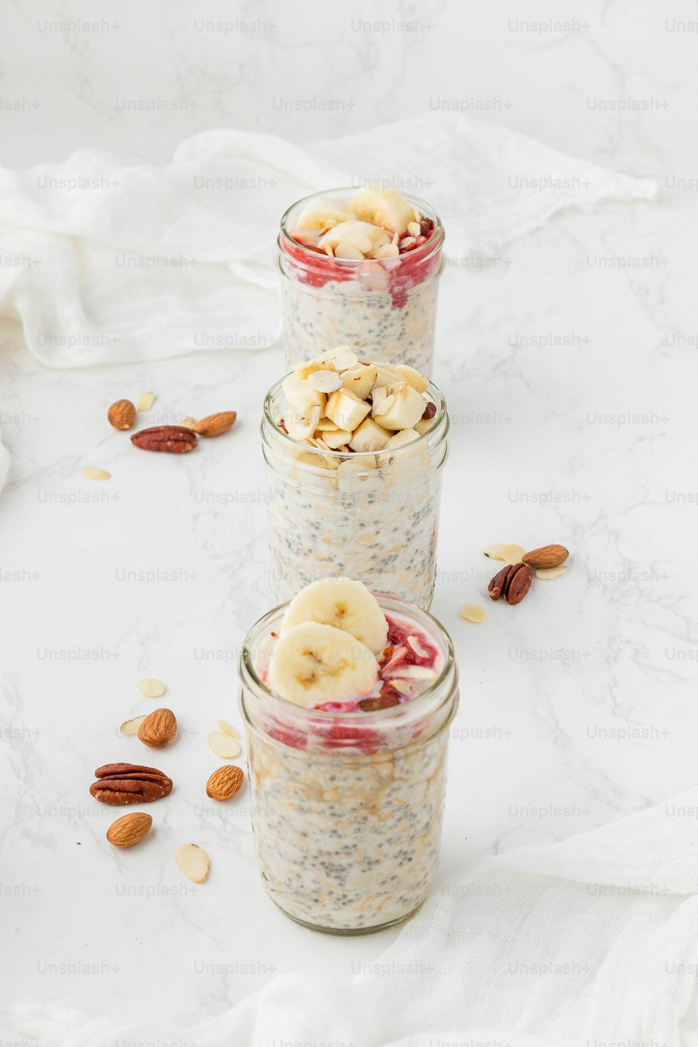 three jars of oatmeal with bananas and almonds