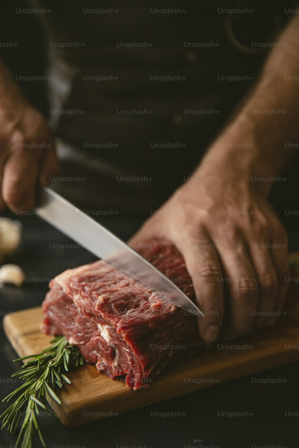 uma pessoa cortando um pedaço de carne em uma tábua de corte
