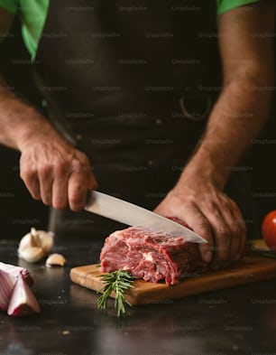 a man cutting up a piece of meat on top of a wooden cutting board