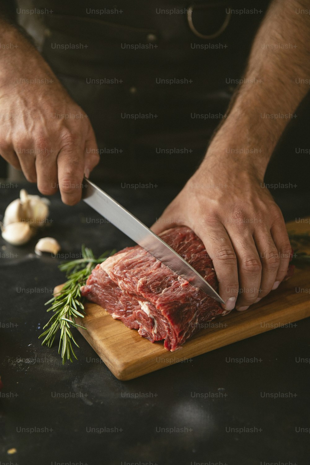 um homem cortando um pedaço de carne em uma tábua de corte