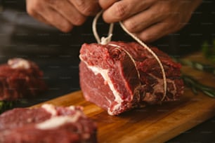 a person cutting up a piece of meat on a cutting board