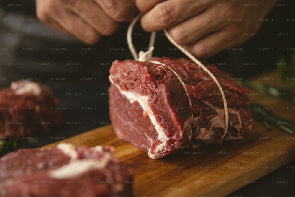 a person cutting up a piece of meat on a cutting board