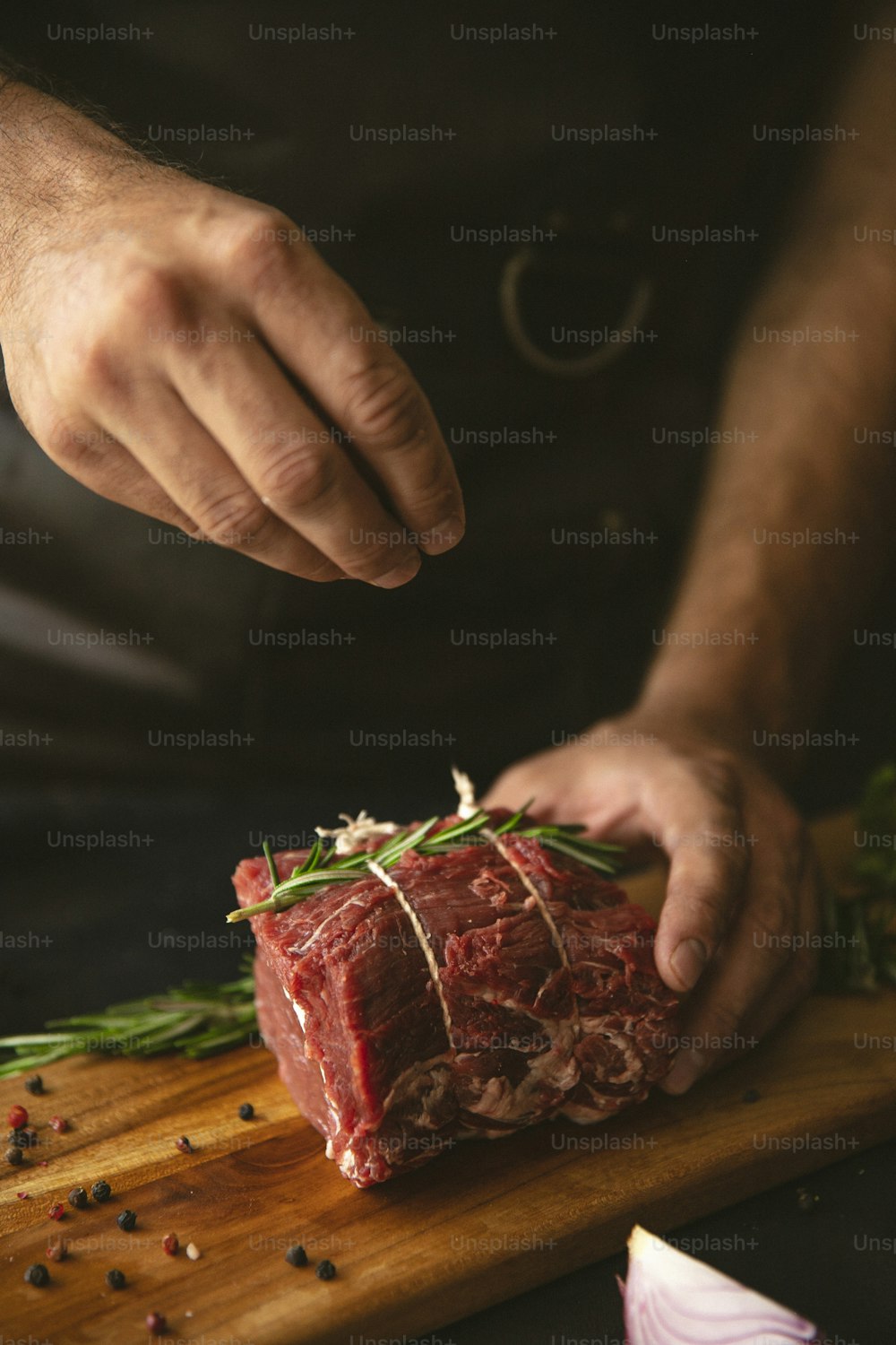 una persona cortando un trozo de carne en una tabla de cortar