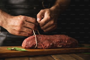 a person cutting up a piece of meat on a cutting board