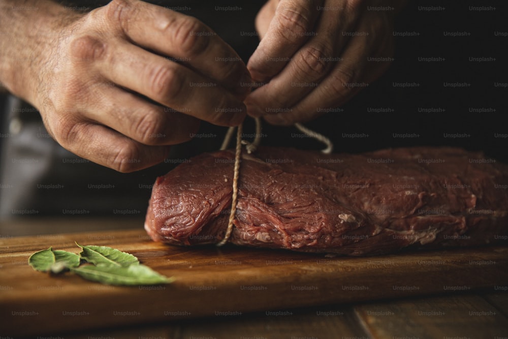 une personne qui découpe un morceau de viande sur une planche à découper