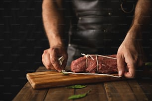 a person cutting up a piece of meat on a cutting board