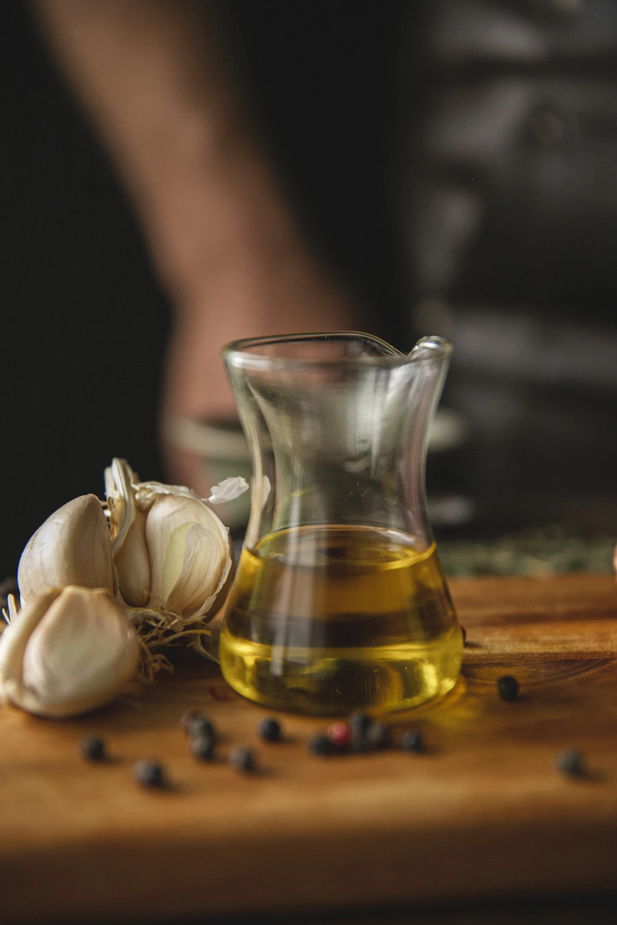 Bouteille d'huile d'olive avec ail sur planche en bois