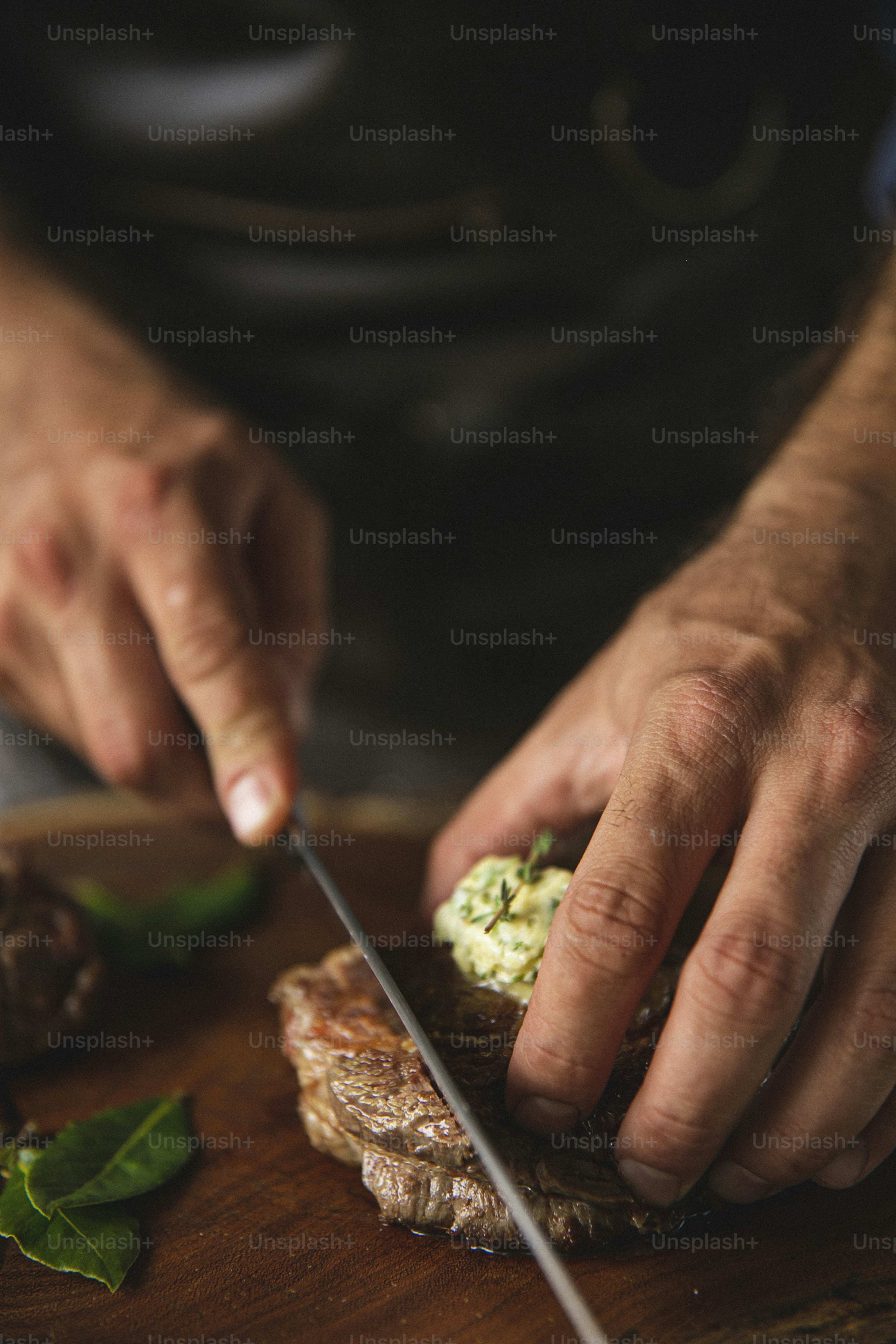 Un hombre cortando comida encima de una tabla de cortar de madera
