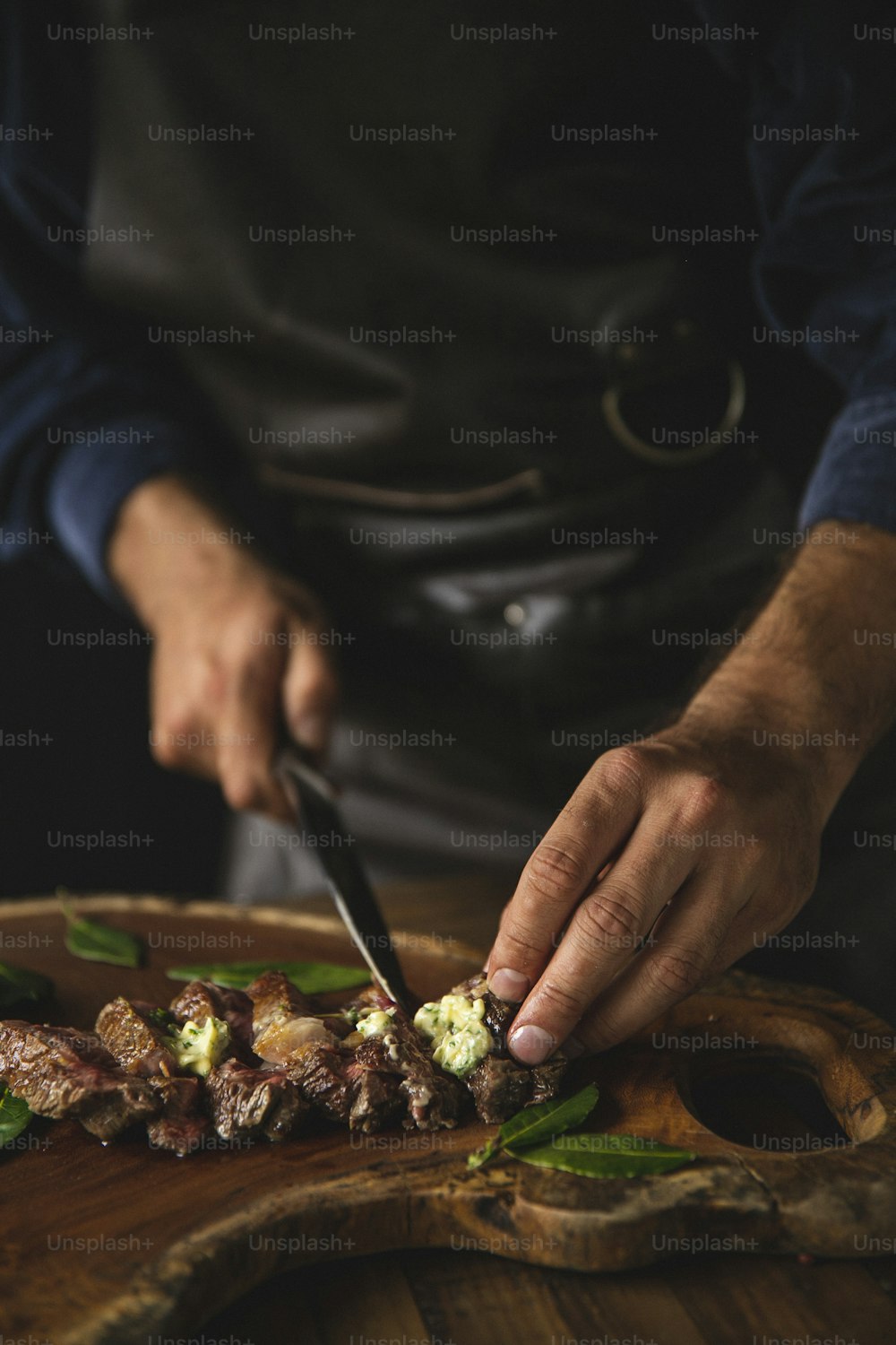 Una persona cortando comida encima de una tabla de cortar de madera