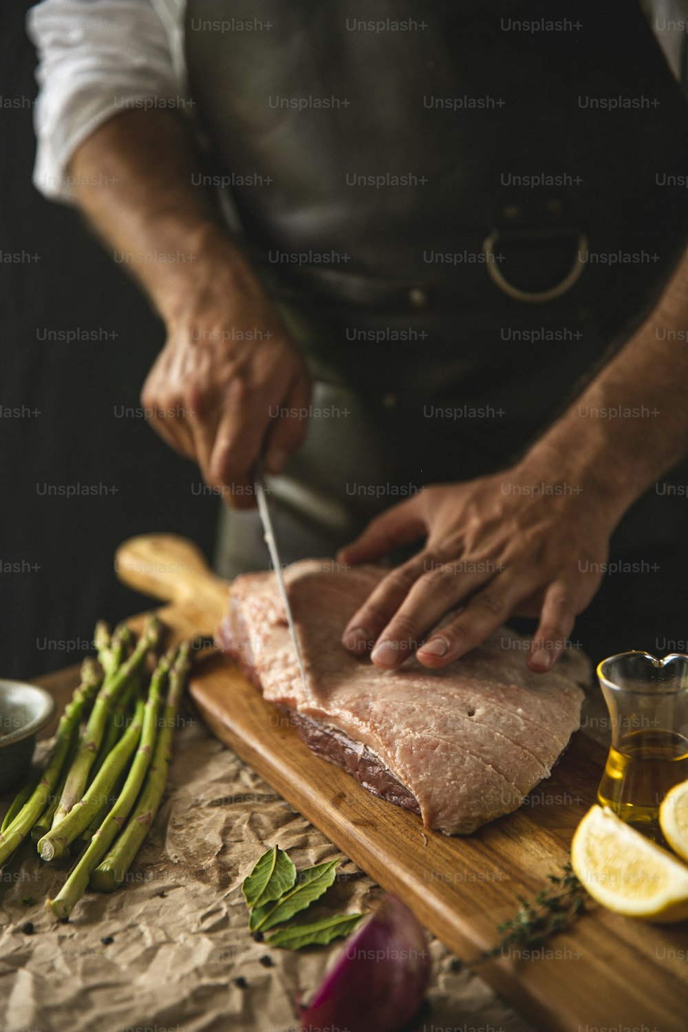 una persona cortando un trozo de carne en una tabla de cortar
