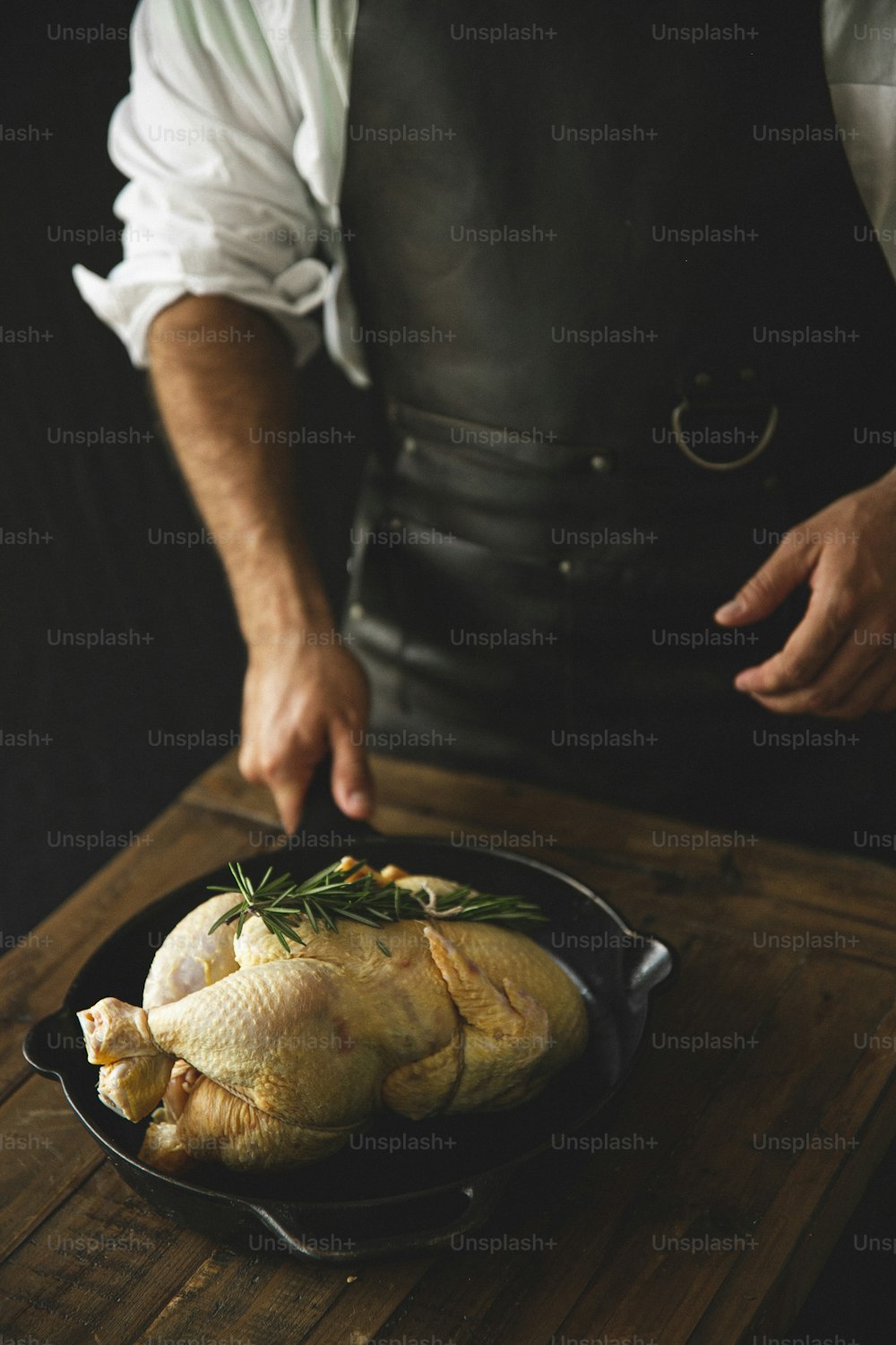 Um homem de avental está cozinhando um peru