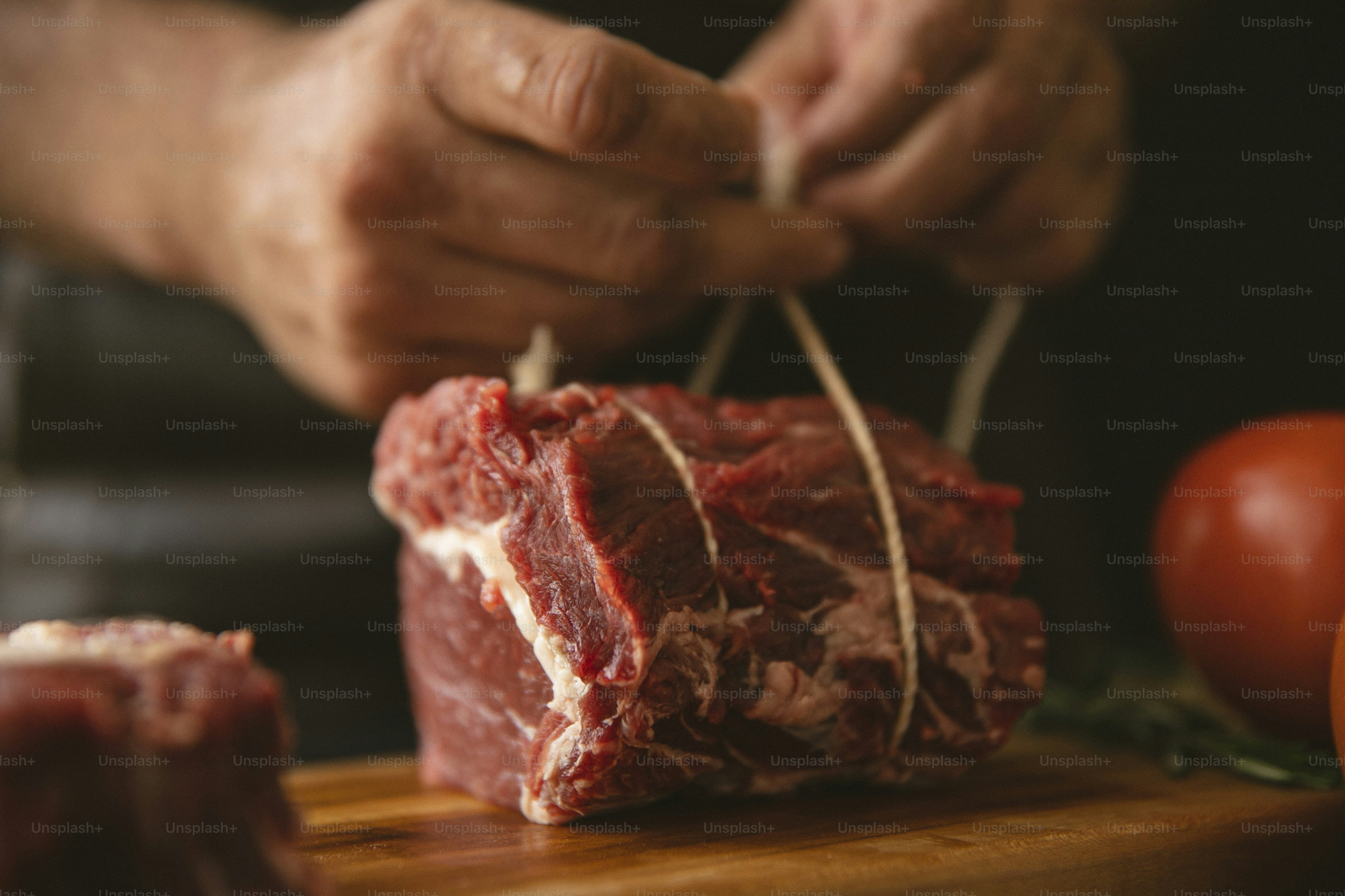 a person cutting up a piece of meat on a cutting board