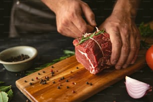 a person cutting up a piece of meat on a cutting board