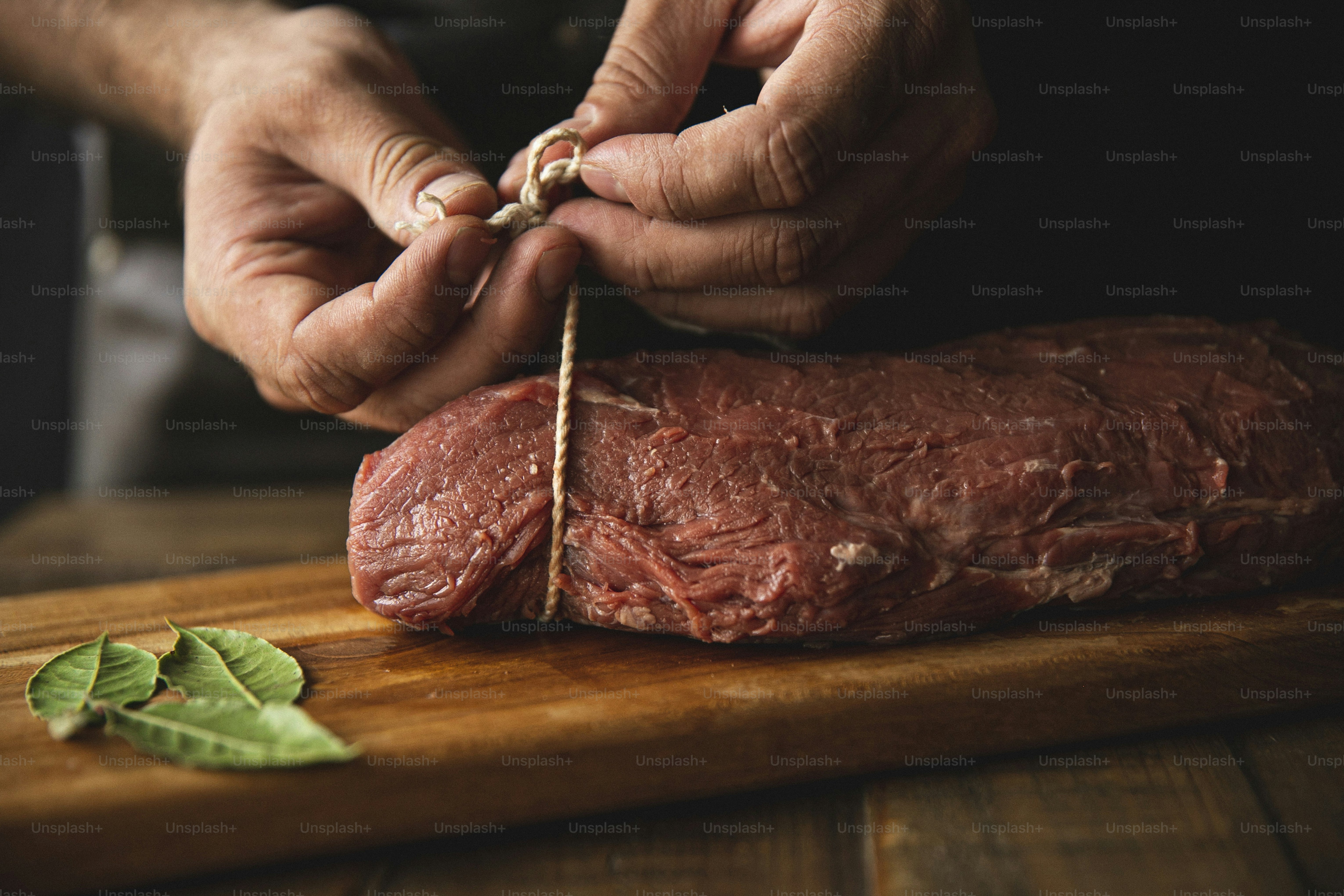 a person cutting up a piece of meat on a cutting board