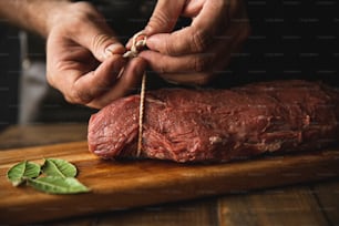 uma pessoa cortando um pedaço de carne em uma tábua de corte