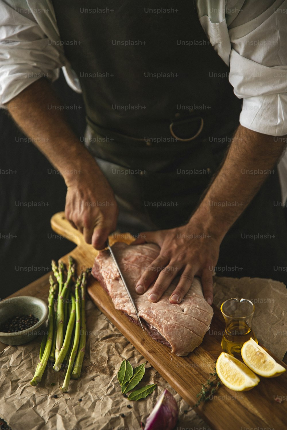 una persona cortando un trozo de carne en una tabla de cortar