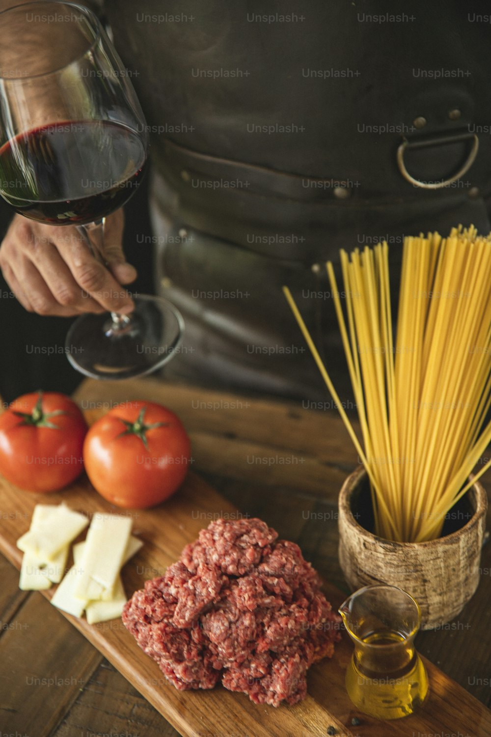 a person pouring wine into a glass next to a plate of food