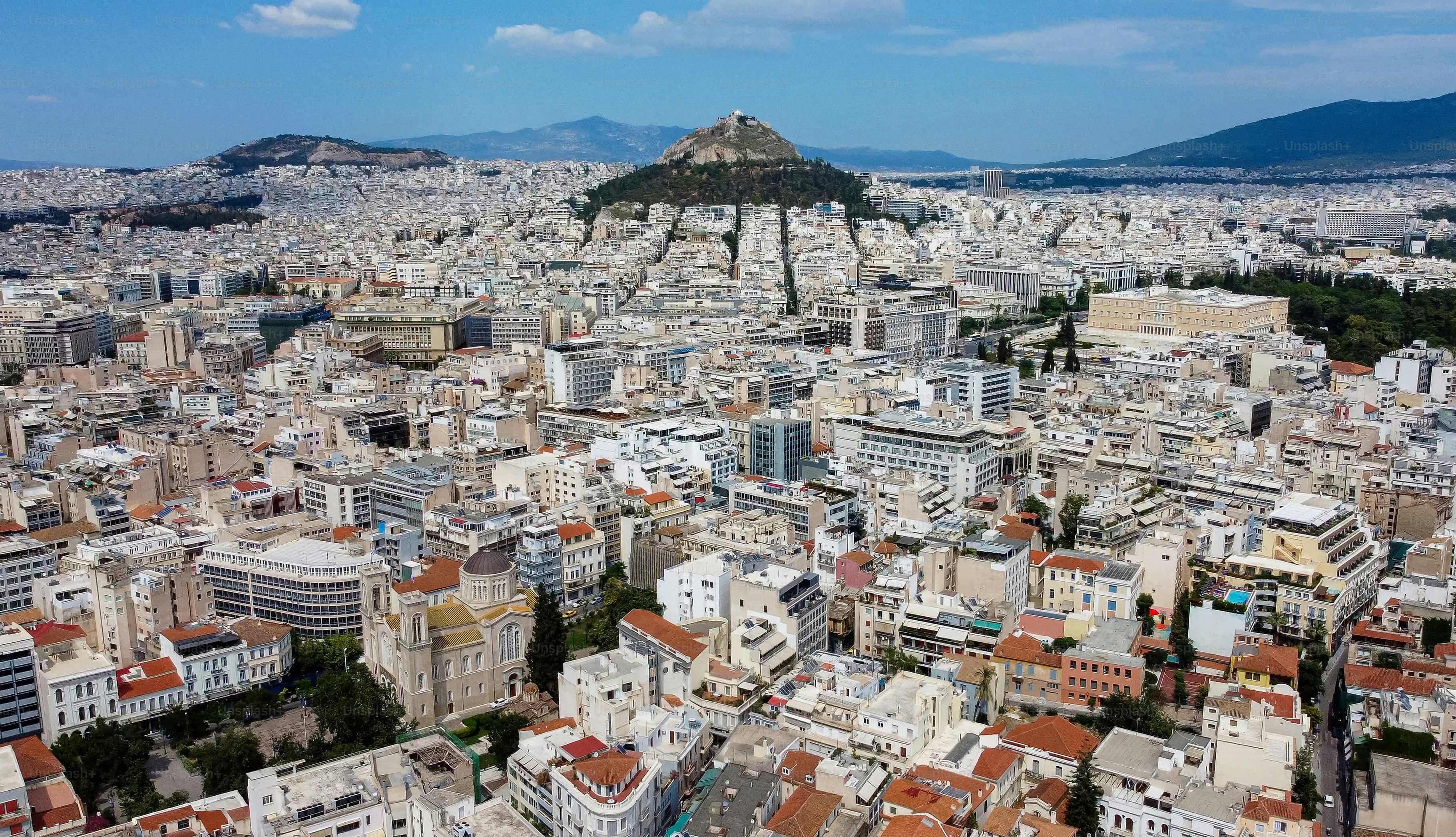 an aerial view of a city with a mountain in the background