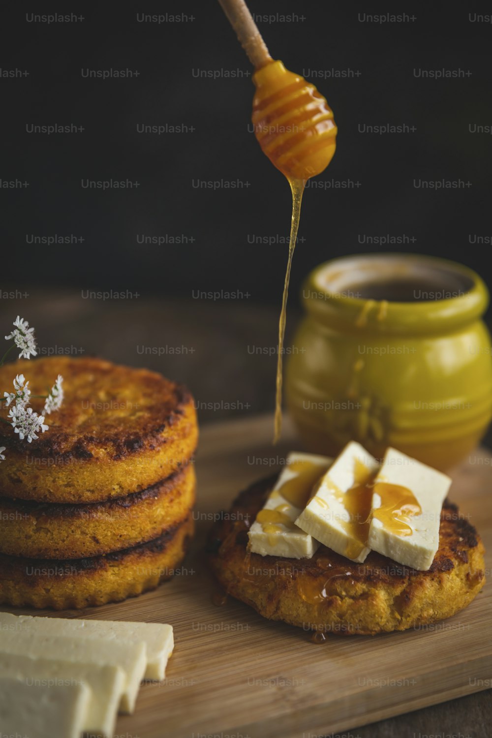 ein Stapel Pfannkuchen auf einem Schneidebrett mit Butter und Sirup