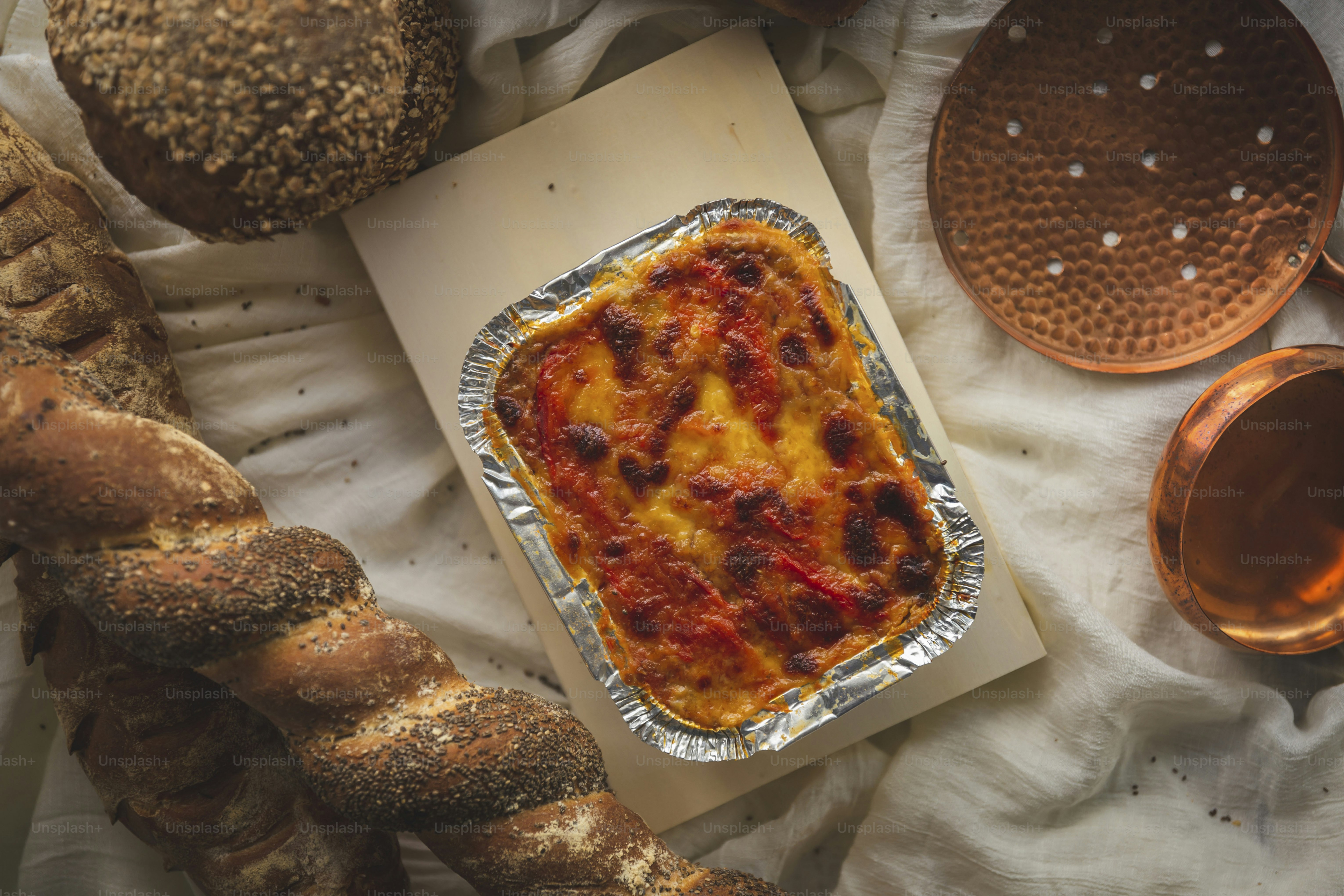 a casserole in a pan on top of a table next to bread