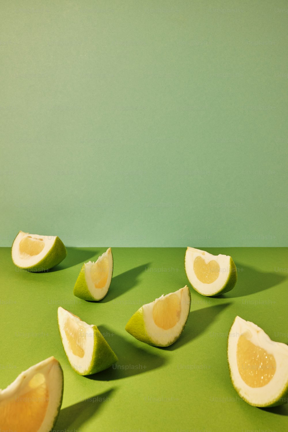 a lime cut in half on a green surface
