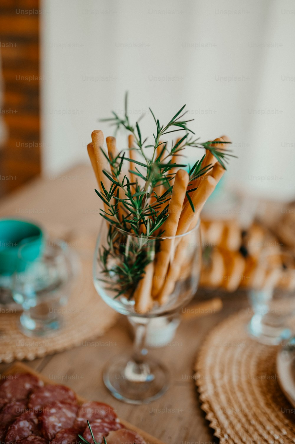 a table topped with a glass vase filled with food