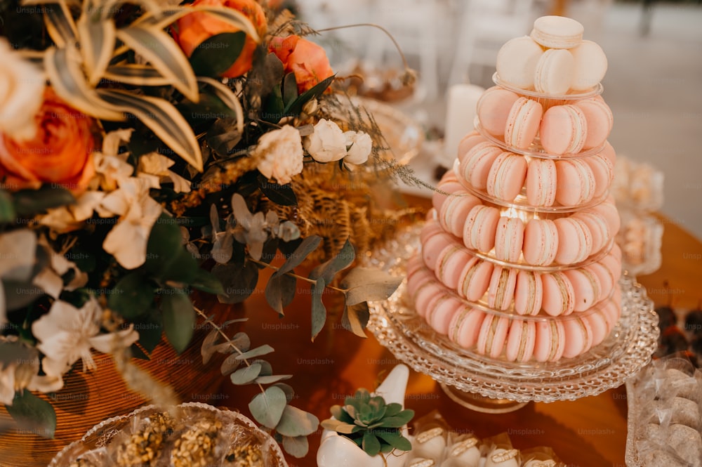 a table topped with a stack of macaroons next to a bouquet of flowers