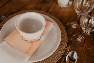 a white plate topped with a white cup and saucer