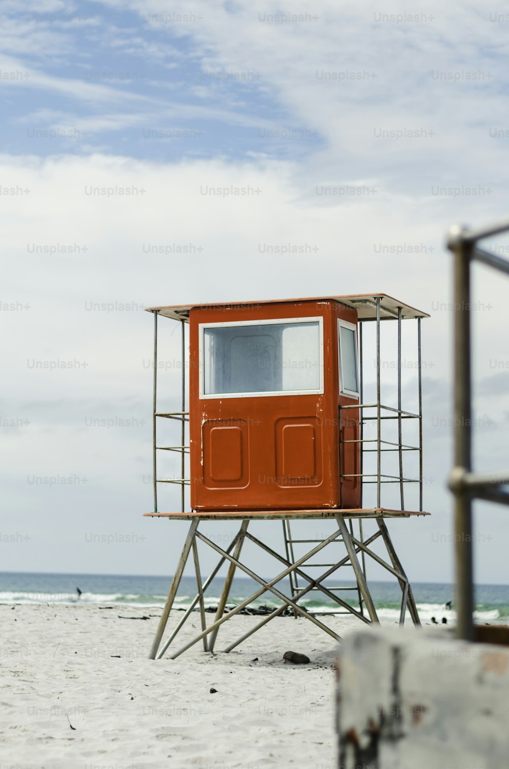 a lifeguard tower on the beach with a sky background