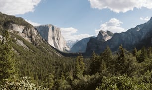 a view of a mountain range with trees and mountains in the background